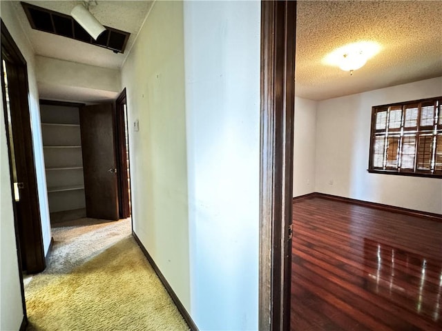 hallway featuring a textured ceiling and hardwood / wood-style floors