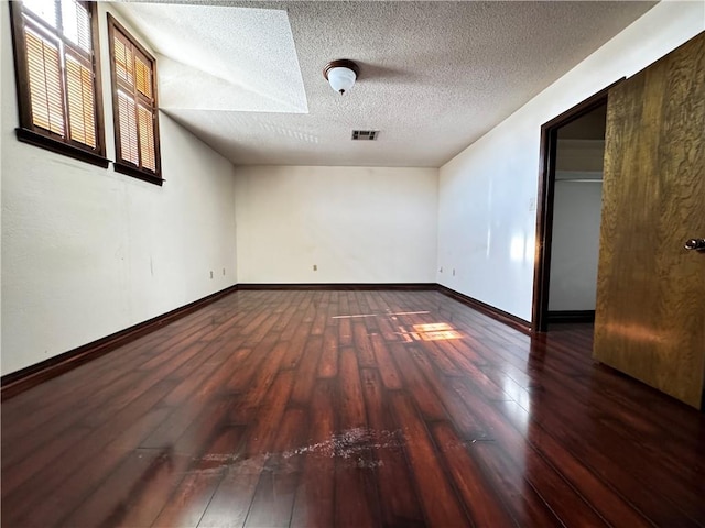 unfurnished room with a textured ceiling and hardwood / wood-style flooring