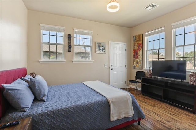 bedroom with wood-type flooring and multiple windows