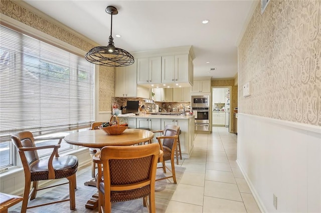 dining area featuring light tile patterned floors and crown molding