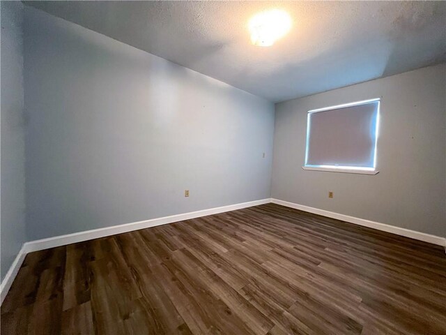 empty room featuring dark hardwood / wood-style flooring and a textured ceiling