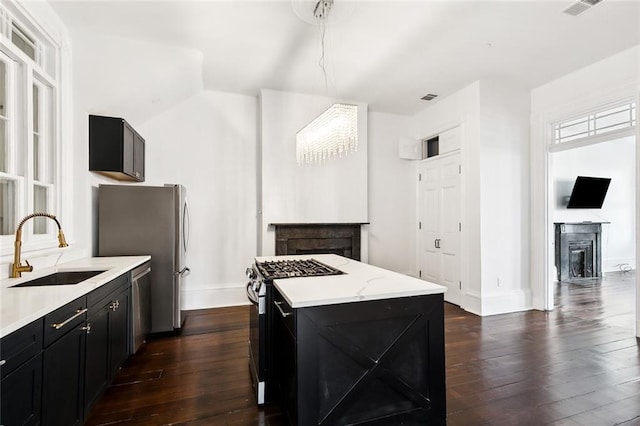 kitchen with a center island, sink, dark hardwood / wood-style floors, and appliances with stainless steel finishes