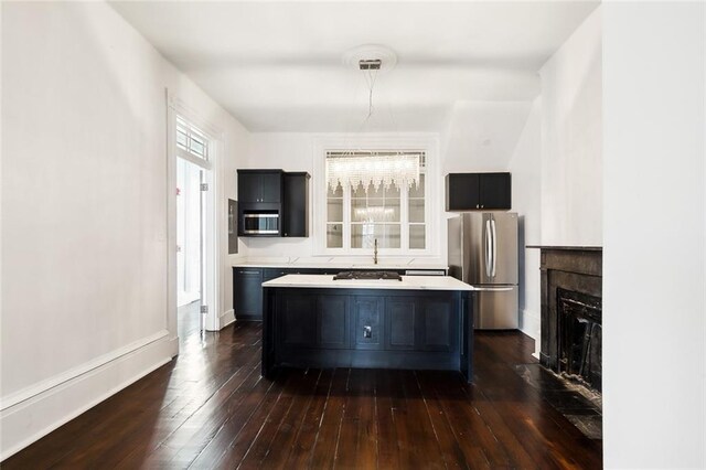 kitchen with stainless steel appliances, a kitchen island, and dark hardwood / wood-style flooring