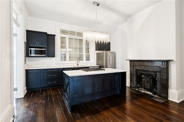 kitchen featuring a kitchen island, appliances with stainless steel finishes, sink, and dark hardwood / wood-style floors