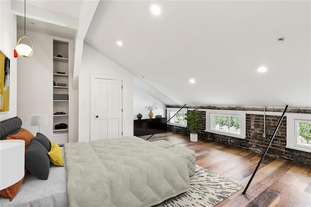 bedroom with multiple windows, hardwood / wood-style floors, and vaulted ceiling