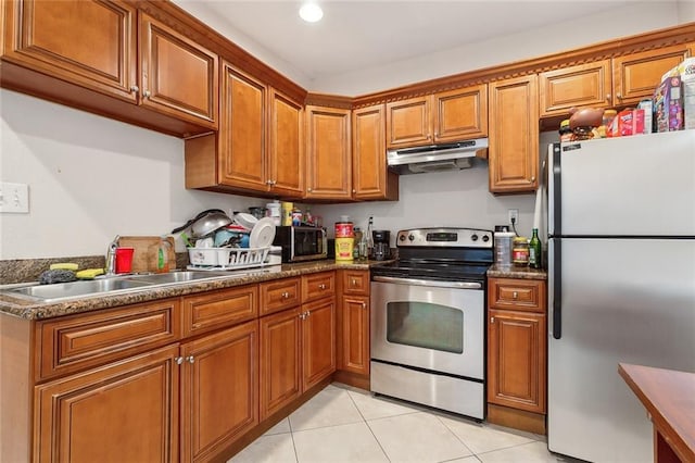 kitchen with appliances with stainless steel finishes, light tile patterned flooring, and sink