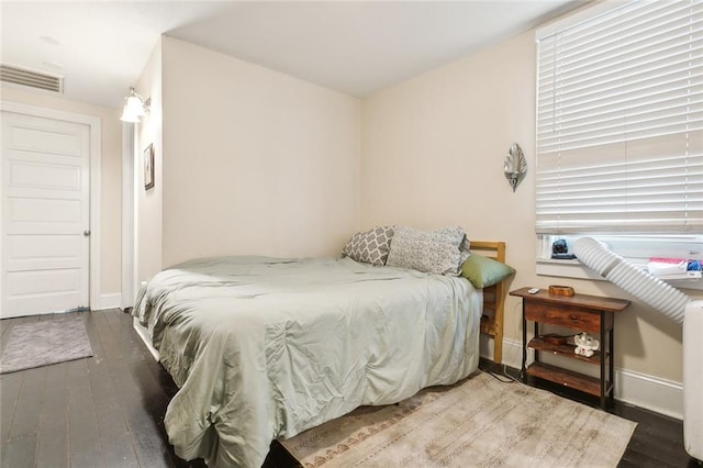 bedroom with dark hardwood / wood-style floors