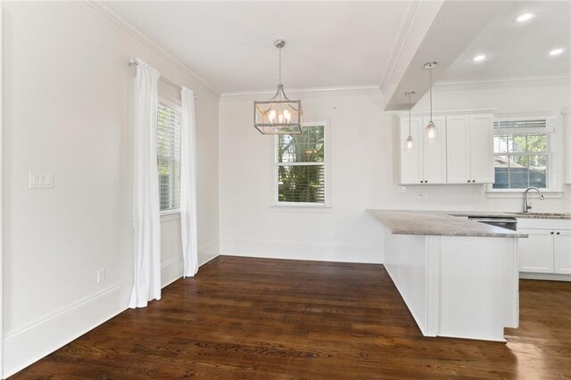 kitchen with a healthy amount of sunlight, kitchen peninsula, dark hardwood / wood-style flooring, and white cabinetry