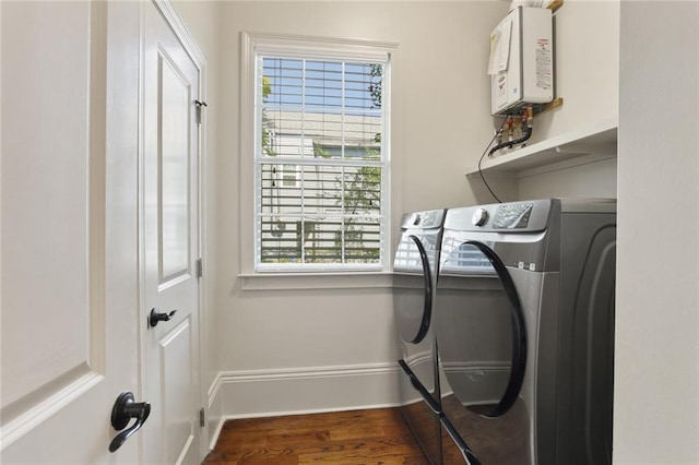 laundry room with washer and clothes dryer, dark hardwood / wood-style flooring, and water heater