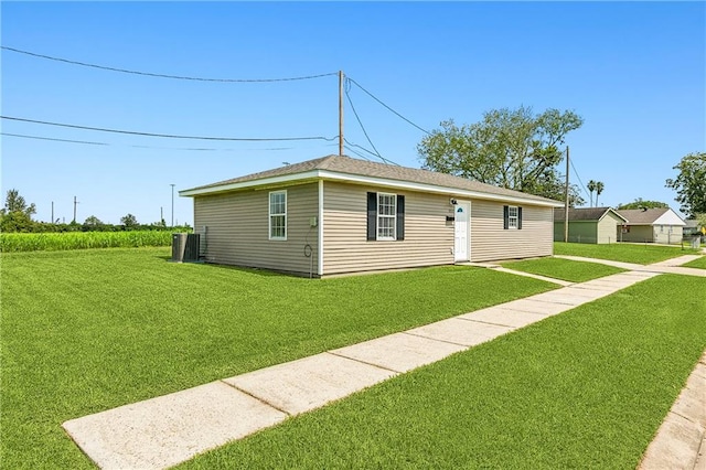 view of front of home with central AC and a front lawn