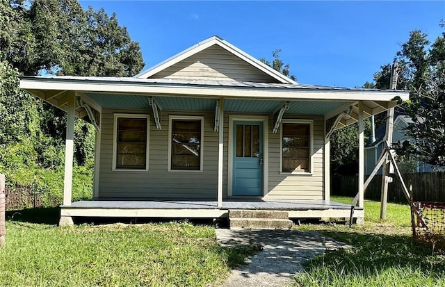 bungalow-style house with a front lawn and covered porch