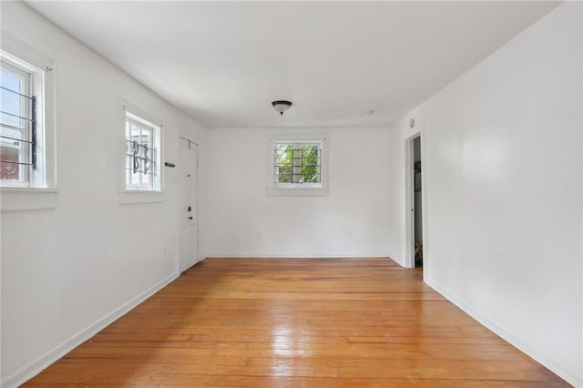 spare room featuring light hardwood / wood-style flooring and plenty of natural light