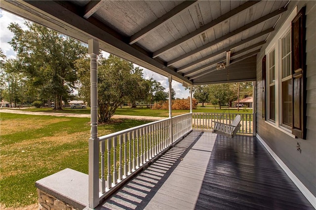 wooden deck featuring a porch and a yard