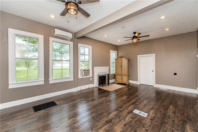 unfurnished living room featuring a textured ceiling, dark hardwood / wood-style floors, ceiling fan, and a wall unit AC