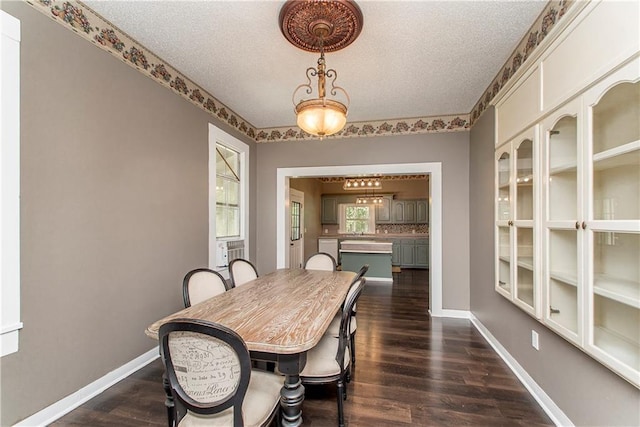 dining room featuring a textured ceiling and dark hardwood / wood-style flooring