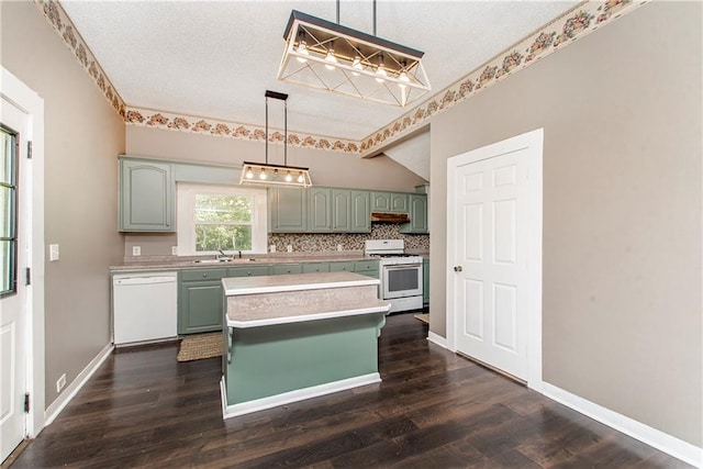 kitchen featuring white appliances, a kitchen island, pendant lighting, dark hardwood / wood-style floors, and sink