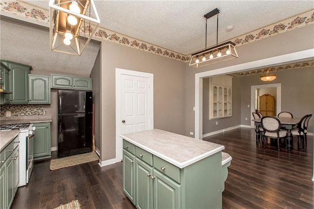 kitchen featuring pendant lighting, green cabinetry, a textured ceiling, and black fridge