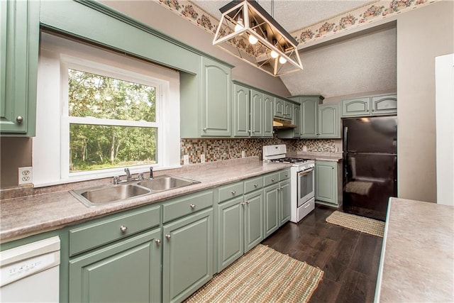 kitchen with hanging light fixtures, dark wood-type flooring, white appliances, a textured ceiling, and sink