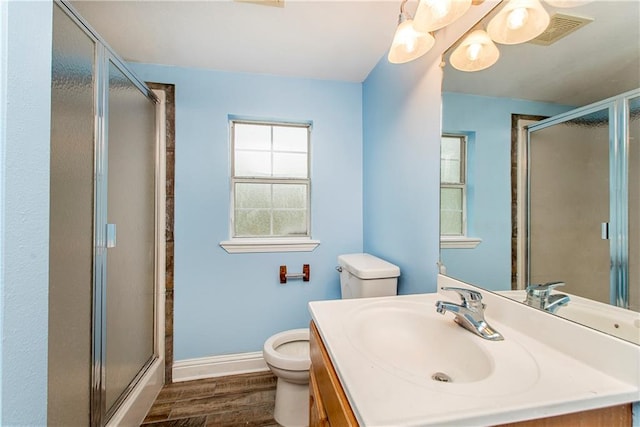 bathroom with hardwood / wood-style floors, vanity, toilet, and a shower with shower door