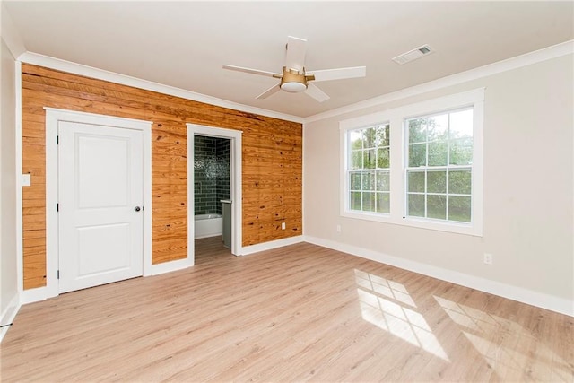 unfurnished room with ceiling fan, light wood-type flooring, wood walls, and ornamental molding