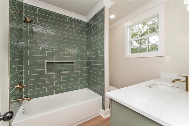 full bathroom featuring tiled shower / bath combo, toilet, vanity, and hardwood / wood-style floors