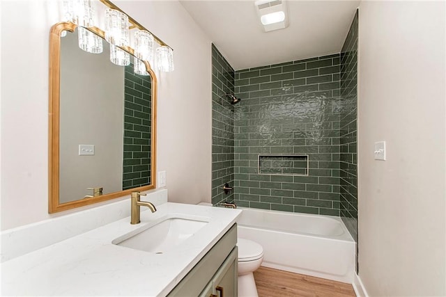 full bathroom featuring wood-type flooring, vanity, toilet, and tiled shower / bath combo