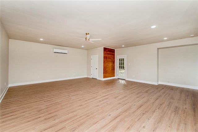 interior space with light hardwood / wood-style flooring, ceiling fan, and a wall mounted air conditioner