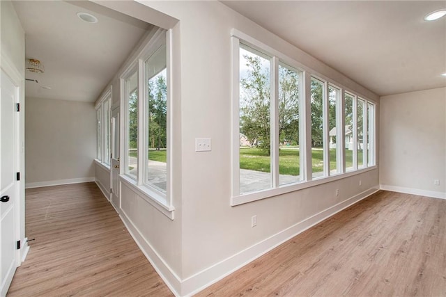 corridor with light hardwood / wood-style flooring and a healthy amount of sunlight