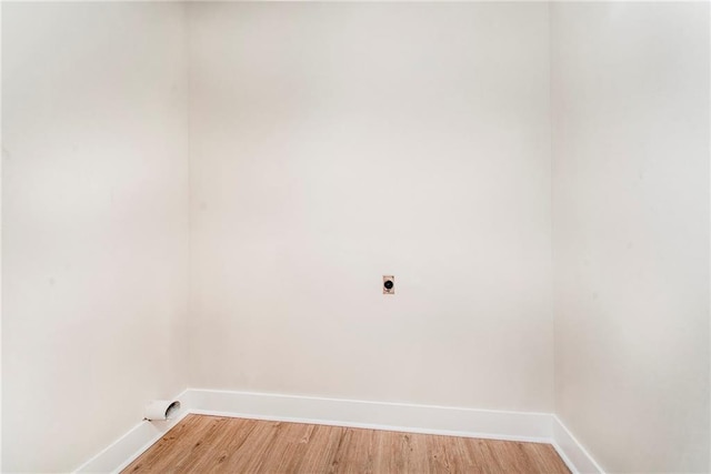 clothes washing area featuring light hardwood / wood-style floors and electric dryer hookup