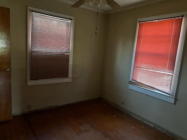 unfurnished room featuring baseboards, crown molding, wood finished floors, and ceiling fan