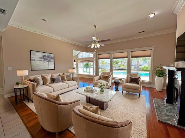 living room with crown molding, hardwood / wood-style floors, and ceiling fan