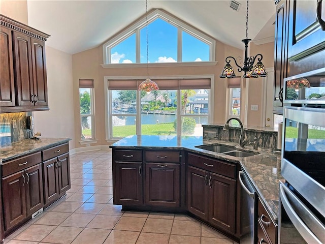 kitchen with a wealth of natural light, sink, decorative light fixtures, and a water view