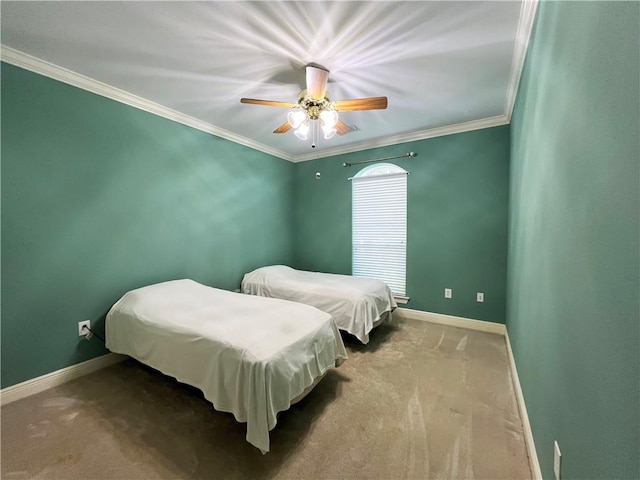 carpeted bedroom with ornamental molding and ceiling fan