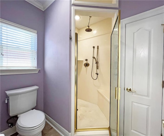 bathroom with ornamental molding, toilet, and an enclosed shower