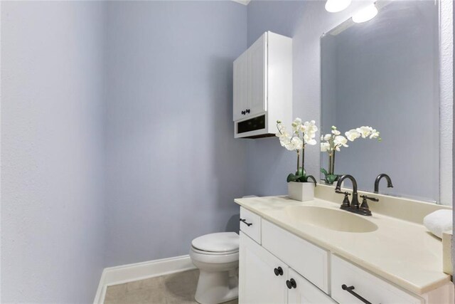 bathroom with tile patterned flooring, vanity, and toilet