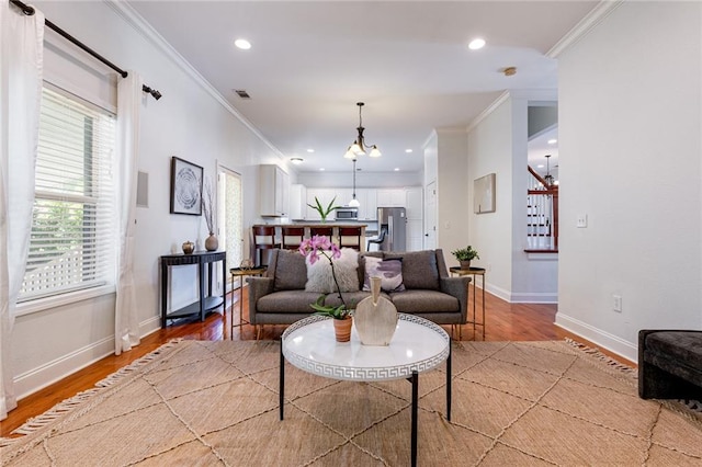 living room with ornamental molding and light hardwood / wood-style floors