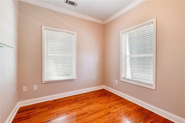 unfurnished room featuring hardwood / wood-style flooring and ornamental molding