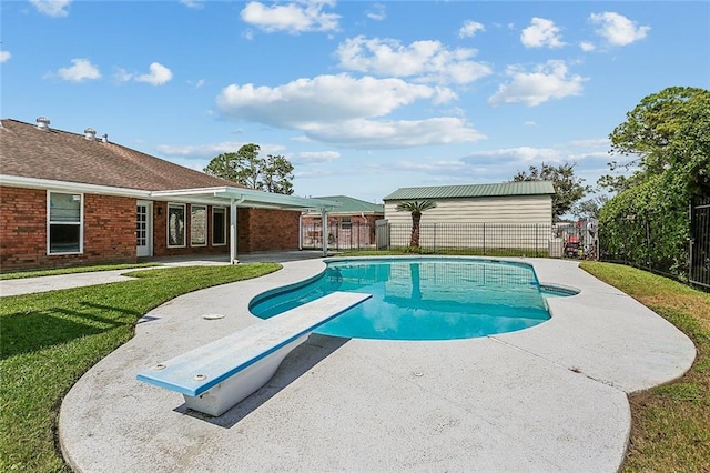 view of pool with a patio, a diving board, and a lawn