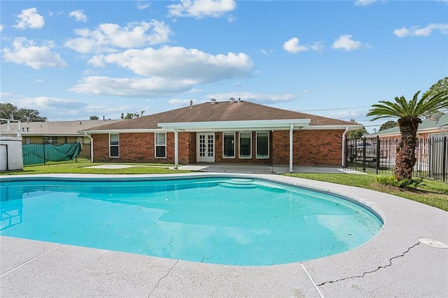 view of pool with a patio area, french doors, and a yard