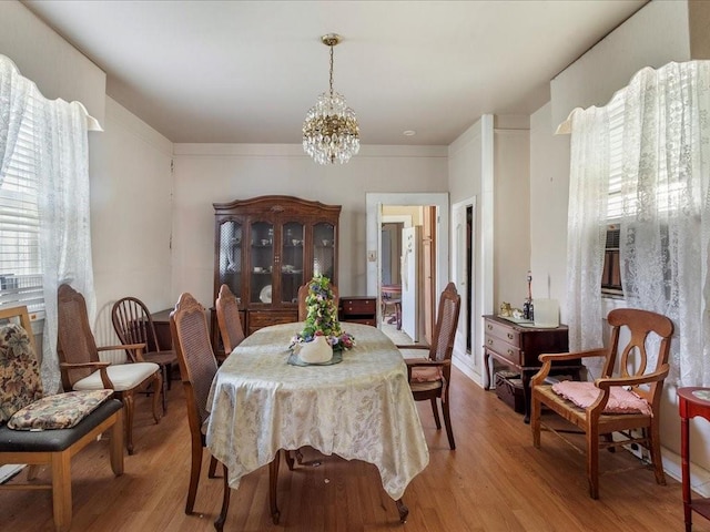 dining space with a chandelier and light wood-type flooring