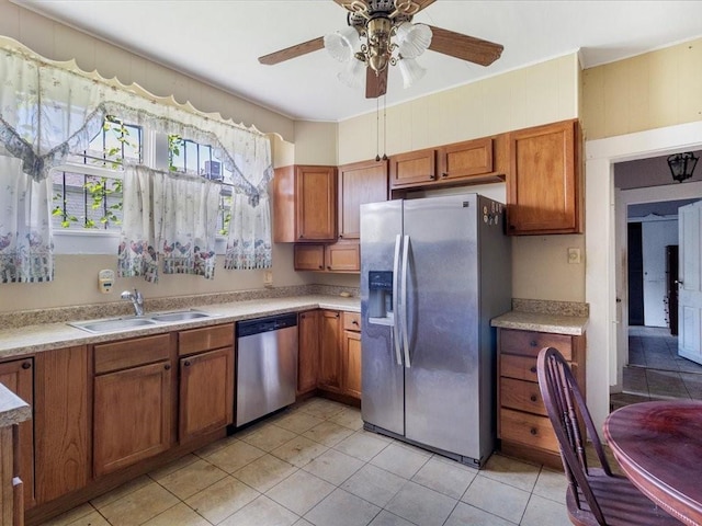 kitchen with ceiling fan, stainless steel appliances, sink, and light tile patterned floors