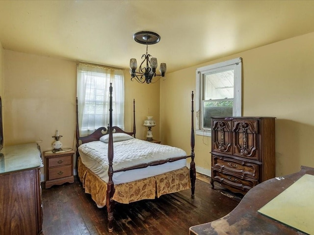 bedroom featuring dark wood-type flooring, a chandelier, and multiple windows