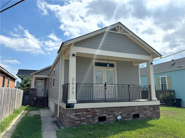 view of front of home featuring covered porch and a front lawn