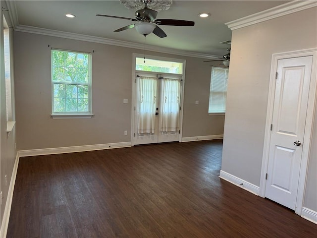 empty room featuring crown molding, dark hardwood / wood-style floors, ceiling fan, and a wealth of natural light