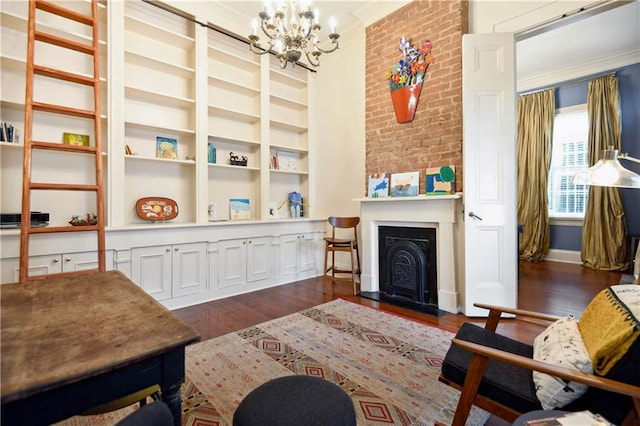 living room featuring a chandelier, crown molding, a fireplace, and dark hardwood / wood-style flooring