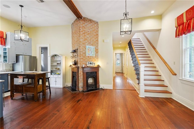 interior space featuring a high ceiling, beam ceiling, a chandelier, and hardwood / wood-style flooring