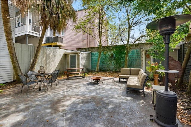 view of patio with a balcony and an outdoor fire pit