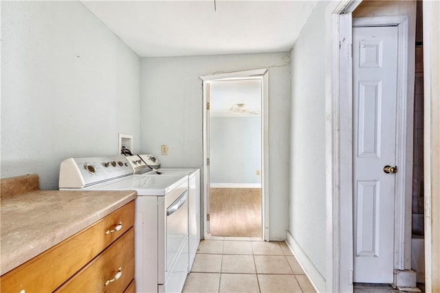 laundry room featuring cabinets, washer and dryer, and light tile patterned flooring