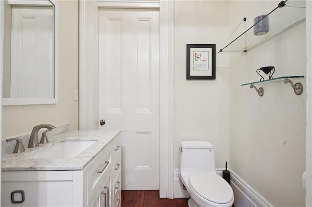 bathroom featuring wood-type flooring, vanity, and toilet