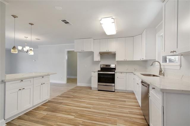 kitchen featuring sink, white cabinetry, hanging light fixtures, light hardwood / wood-style flooring, and appliances with stainless steel finishes